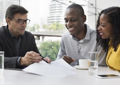 Couple meeting advisor sitting at a table with coffee